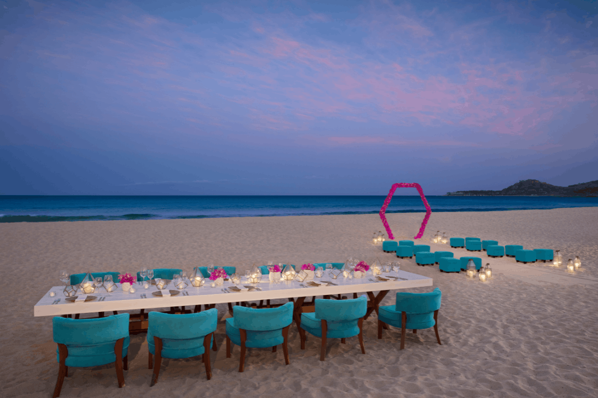 Recepción de boda en la playa de Krystal Grand Los Cabos con montaje elegante al atardecer frente al mar.